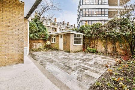 Neat paved patio and small garden near wooden fence