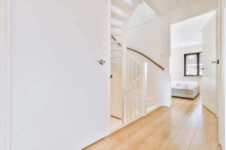 Hallway with white walls with white wooden stairs