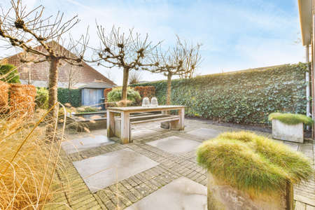 Terrace in the garden of a house with wooden simple table and chairs