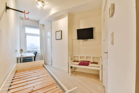 Minimalist interior of study room with parquet floor and white walls furnished with settee and table...