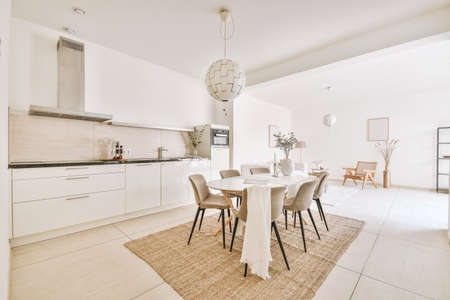 Large kitchen room with white appliances ,wooden white dining table and chairs