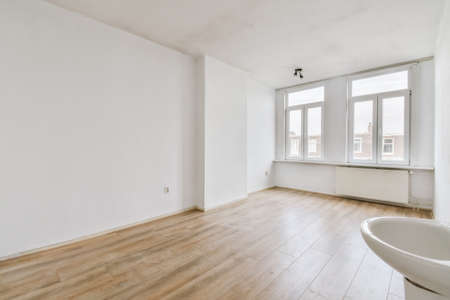 Plastic window and radiator on white wall in empty light room at home