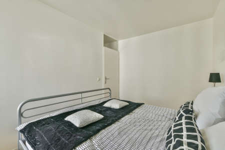 A spacious bright bedroom with a minimalistic bedside table and a large panoramic window