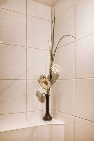 Flowers in a vase as a decor for the bathroomの写真素材