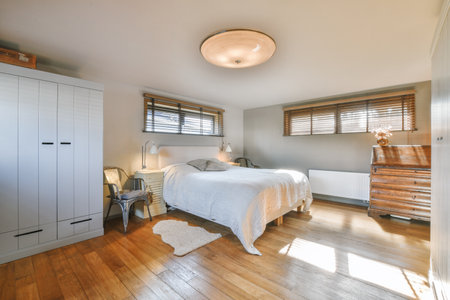 Home interior design of bedroom with bed and wooden wardrobe placed in corner near window in modern...