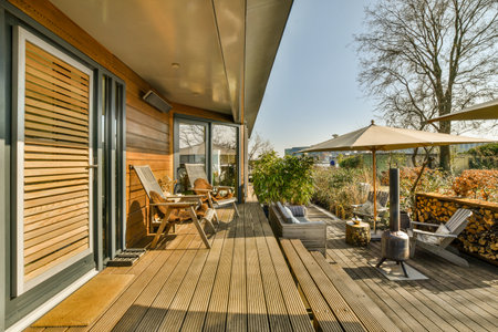 Neat paved patio with sitting area and small garden near wooden fence