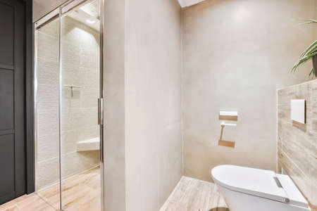 Sink base cabinet and mirror cabinet in white tiled bathroom with wall hung toilet