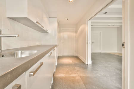 Spacious bright kitchen with white walls and tiled floor