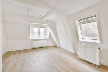 Plastic window and radiator on white wall in empty light room at home