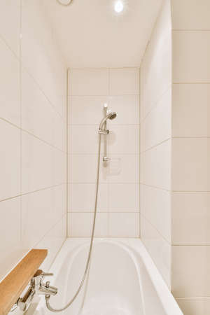 Sinks with mirrors and clean bathtub located near shower box with glass door in modern bathroom with...