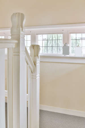 White stairway connecting levels of contemporary house with wooden floor and white walls