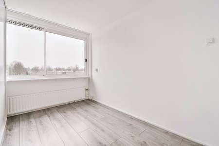 Plastic window and radiator on white wall in empty light room at homeの写真素材