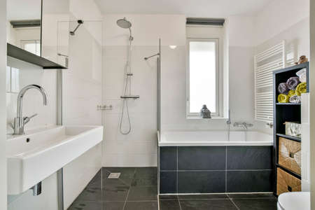 Cozy bathroom with a sink, shower, toilet and bathtub in a modern house