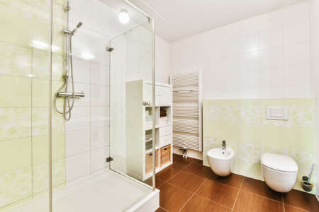 The interior is a mind-blowing bathroom with a brown tiled floor and toilet