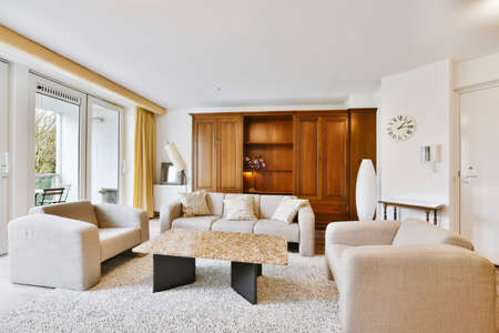 The interior of a delightful living room with a white sofa and a wooden wardrobeの写真素材