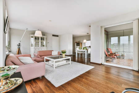 The interior of a stunning living room with a pink sofas and a lamp