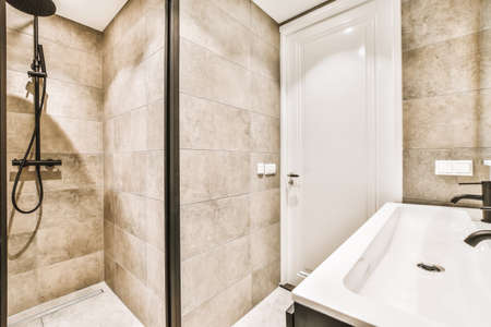 Luxurious bathroom interior with large sink and beige tiles
