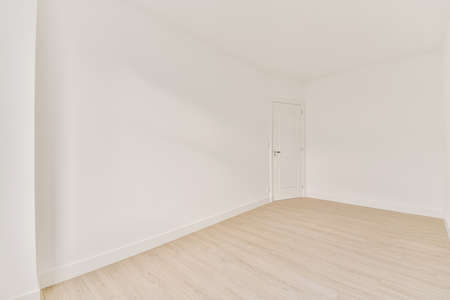 The interior of a beautiful room with white walls and parquet floors