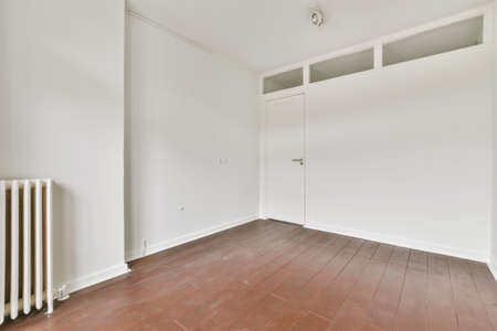 The interior of a stylish room with white walls and wooden floor