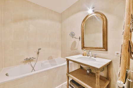 Sinks with mirrors and clean bathtub in modern bathroom with white tiled walls