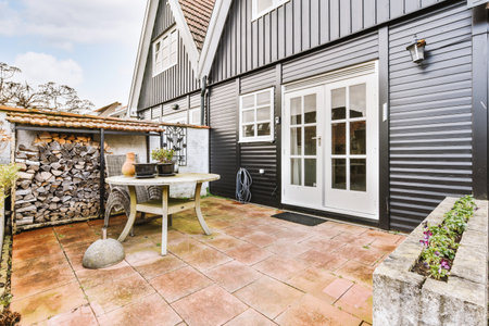 Neat paved patio with sitting area and small garden near wooden fenceの写真素材