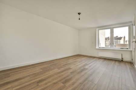 Plastic window and radiator on white wall in empty light room at homeの写真素材