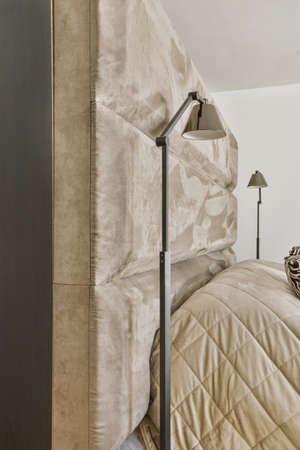 Interior of light bedroom with queen size bed and classic armchair against big windowsの写真素材