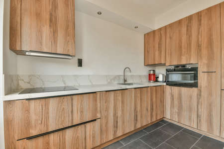 Spacious bright kitchen with white walls and tiled floor