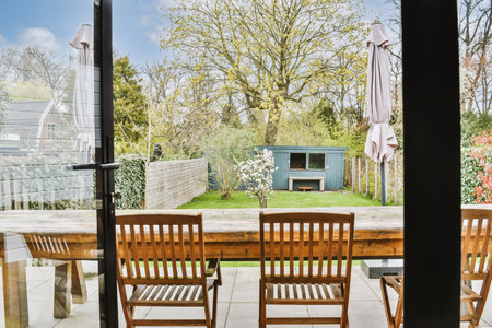 Neat paved patio with a seating area and a small garden near a wooden fence