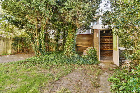 Neat paved patio with sitting area and small garden near wooden fence