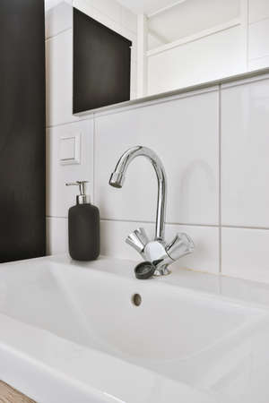 Modern home interior design of white bathroom with open bathtub and shower separated from toilet by...