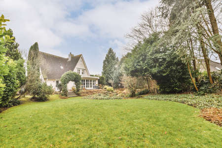 Neat paved patio with sitting area and small garden near wooden fence