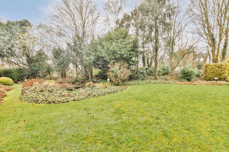 Neat paved patio with sitting area and small garden near wooden fence