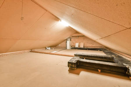 Open plan studio apartment with triangle shaped roof and construction of wooden beams in daylightの写真素材