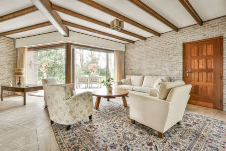Stylish luxury home interior design of cozy living room with burning fireplace and comfy sofa and...