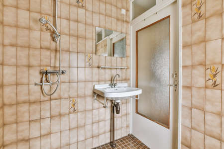 Sink base cabinet and mirror cabinet in white tiled bathroom with wall hung toiletの写真素材