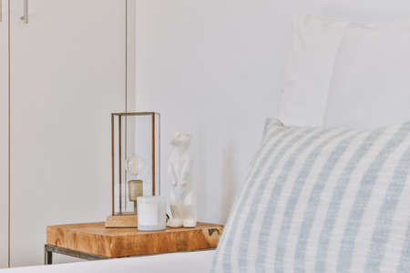 Home interior design of bedroom with bed and wooden wardrobe placed in corner near window in modern apartmentの写真素材