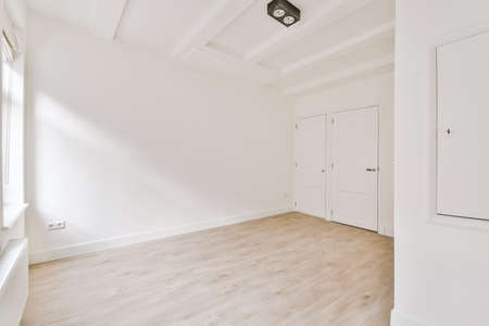 Plastic window and radiator on white wall in empty light room at home