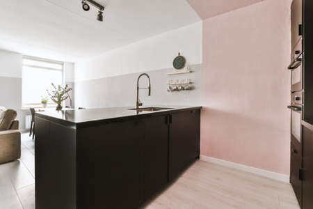 Simple interior of light living room with gray sofa in front of TV and dining table against windowの写真素材