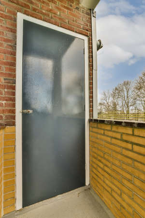 Narrow brick balcony with metal railings and door