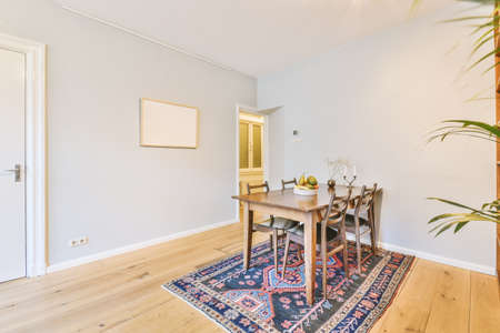 Comfortable couch located near carpet and table against window in spacious minimalist style living...