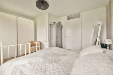 A spacious bright bedroom with a minimalistic bedside table and a large panoramic window