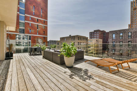 Neat paved patio with sitting area and small garden near wooden fence