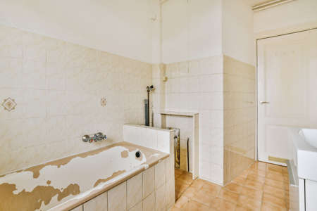 Sinks with mirrors and clean bathtub in modern bathroom with white tiled walls