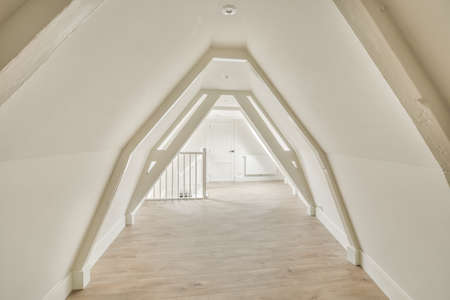 A cozy and spacious mansard styled empty room in a luxury house