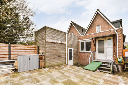 Spacious garage with closed white door and wooden walls with hangers on it