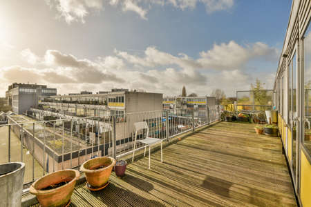 Panoramic view of old brick buildings with parking and trees from small balcony
