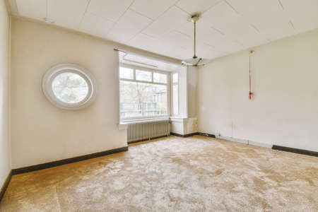 Plastic window and radiator on white wall in empty light room at home