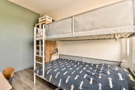 Interior of modern kid bedroom with bed and shelves with various toys at home