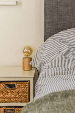 Comfortable bed and chairs located in near wall with framed painting in contemporary bedroom at home